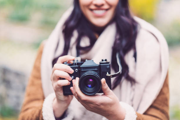 istock Woman holding camera and smiling 907963298