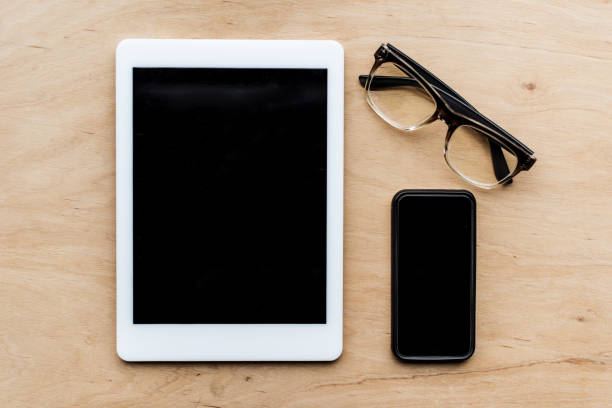 istock top view of tablet, glasses and smartphone on wooden surface 907963396