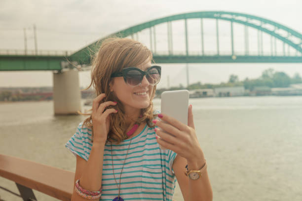 Cute girl posing for a good selfie with cellphone.