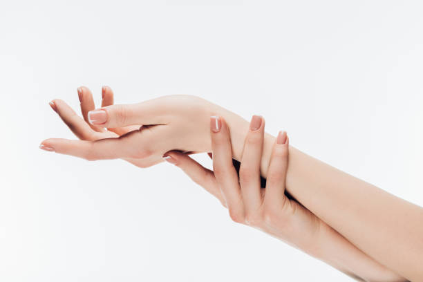 istock woman with stylish nails applying cream on hands 907967530