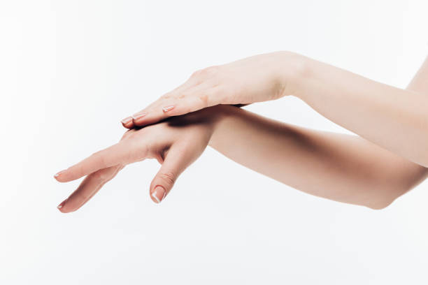 istock woman applying cosmetic cream on hands isolated on white 907968064