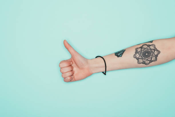 istock woman showing thumb up isolated on turquoise 907968818