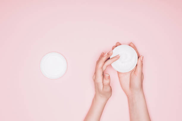 woman taking moisturizing cream from can isolated on pink cropped shot of woman taking moisturizing cream from can isolated on pink animal representation photos stock pictures, royalty-free photos & images