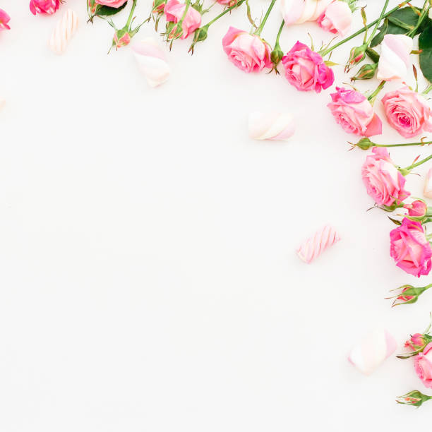 istock Floral frame of roses and marshmallow on white background. Flat lay, Top view. 907970278