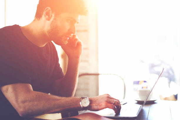 istock Concentrated businessman browsing internet websites in searching important information on laptop computer with wireless 4G connection sitting in coffee shop interior.Pensive student watching webinar 907971020