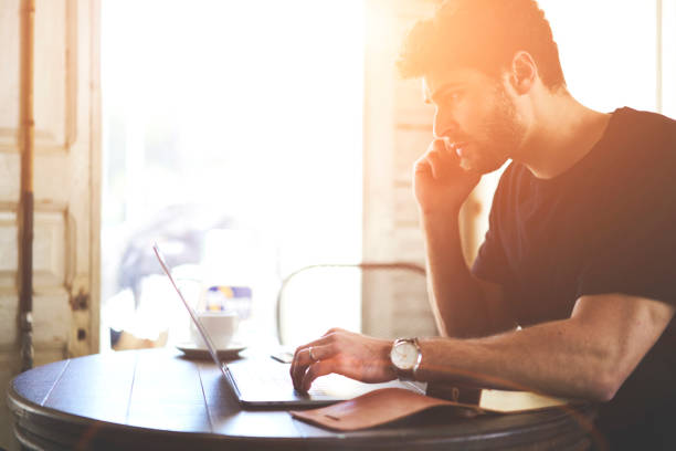 istock Concentrated businessman browsing internet websites in searching important information on laptop computer with wireless 4G connection sitting in coffee shop interior.Pensive student watching webinar 907971142