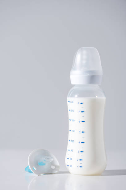 istock close-up view of plastic bottle with milk and nipple on grey 907971178