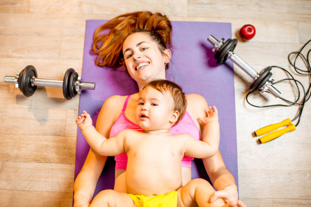 istock Mother with baby boy exercising on the floor 907971814