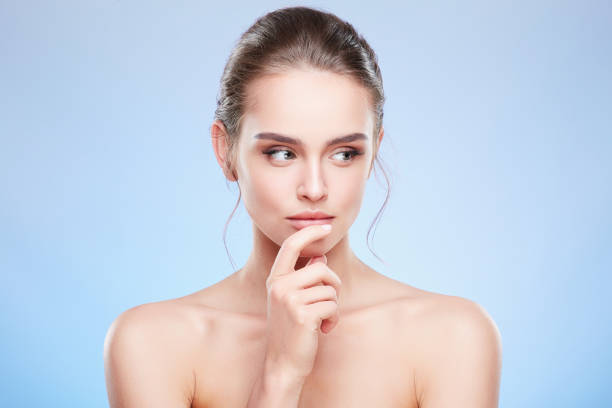 istock Woman touching lower lip and looking aside slyly 907972346