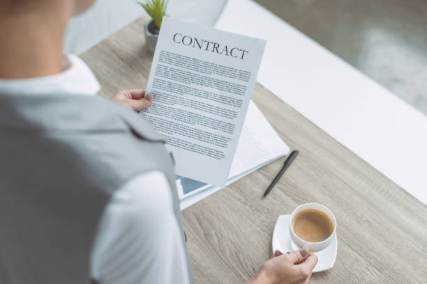 istock cropped image of businesswoman reading contract 907972964