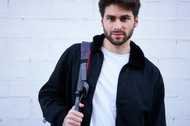 istock Half length portrait of good looking traveler with backpack posing for camera while spending free time outdoors.Handsome confident hipster guy having recreation during walking at urban setting 907973018