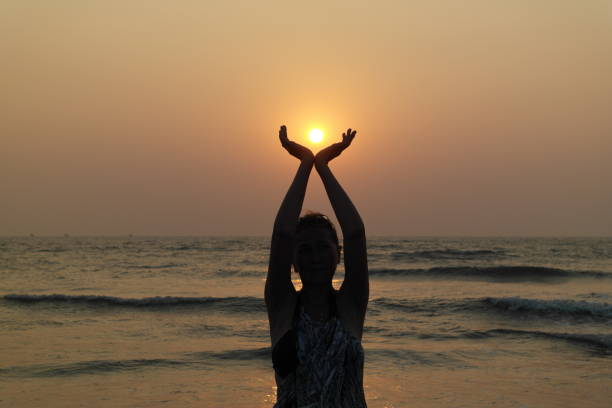 Girl and sun The beautiful girl holds the sun falling in the sea in palms religion sunbeam one person children only stock pictures, royalty-free photos & images