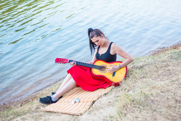 istock Young woman playing guitar. 907974322
