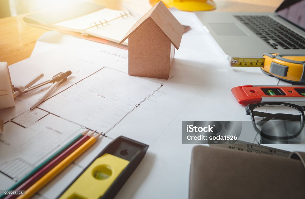 Architect concept. Business objects of engineer or architect on desk with engineer tools and architect analyzer working with blueprints and model house for startup new construction project in office.Engineering tools. Apartment Stock Photo