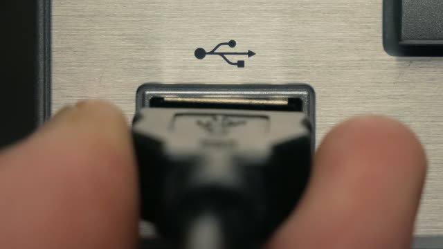 The man connects black USB cable. Close-up
