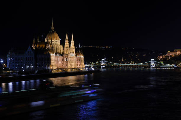 hungarian parliament and the danube river illuminated at night. - budapest houses of parliament london city cityscape imagens e fotografias de stock