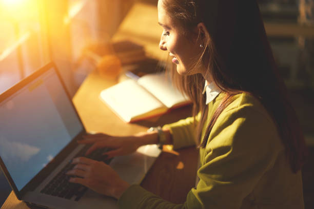 istock Smiling brunette student using laptop with mock up screen for chatting in social networks typing text of message, positive female manager satisfied with completing online report sitting in cafe 907984974