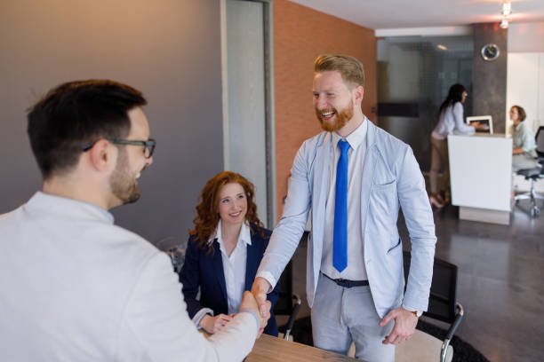 istock Couple talking to loan officer and shaking hands 907987878
