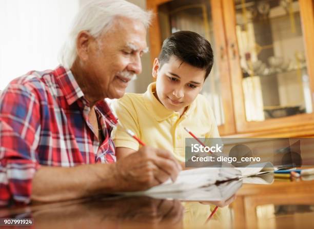 Little Boy Doing School Homework With Old Man At Home Stock Photo - Download Image Now