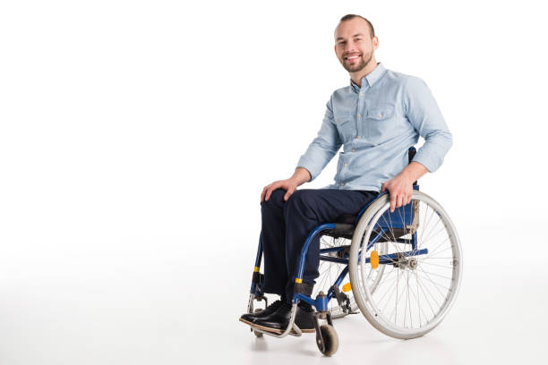 Handsome man in wheelchair smiling disabled man in wheelchair looking at camera, isolated on white wheelchair stock pictures, royalty-free photos & images