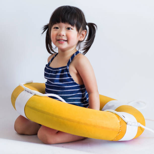 Cute and innocent japanese kid with life ring on white background stock photo