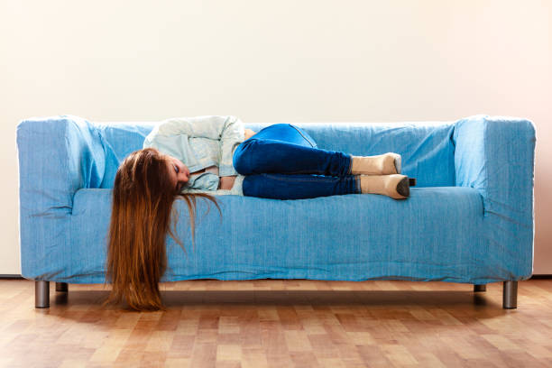 istock Sad woman laying on couch 907992316