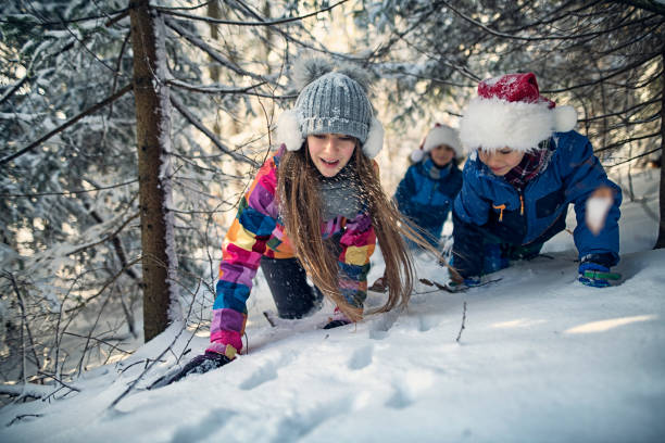 Three children following animal tracks on snow