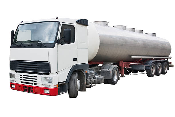A polished stainless steel tanker truck reflecting the surrounding landscape, parked on a sunny day. The vivid blue sky contrasts with the metallic surface, highlighting the vehicle's industrial design and functionality