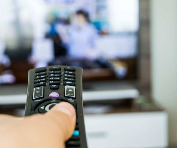 istock resting at home and watching television, zapping with remote control, watching people watching TV at home 907998132
