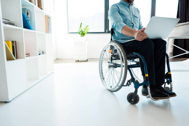 istock businessman in wheelchair using laptop 907999006