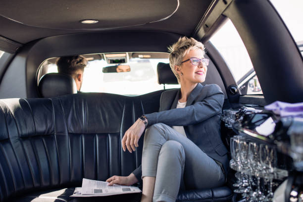 young business woman is sitting in limo - reading newspaper 30s adult imagens e fotografias de stock