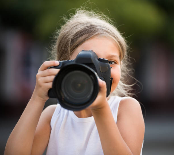 istock girl  holding photo camera 908001908