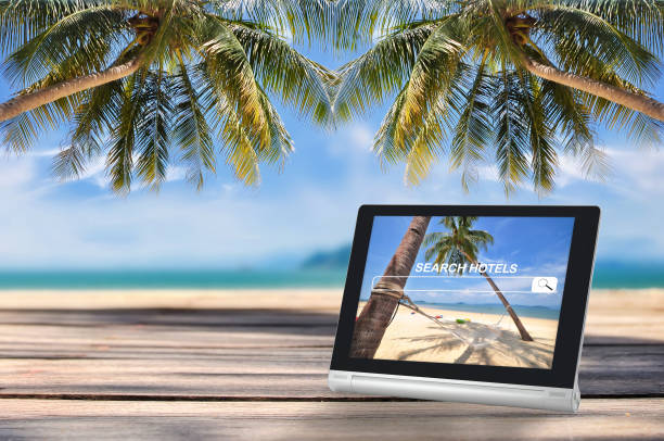 istock Computer tablet with search hotel website screen on tropical beach background 908003020