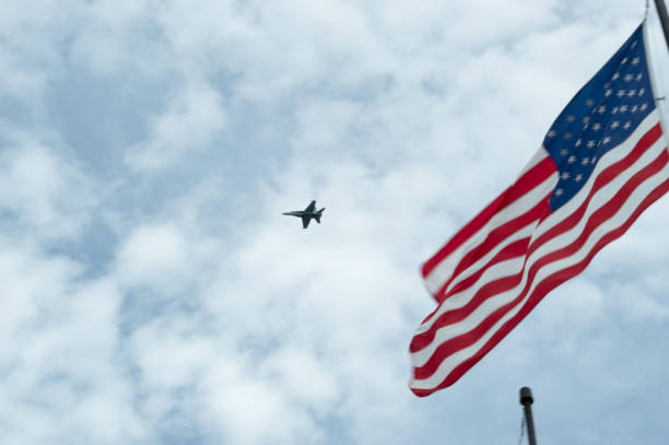 fa-18 hornet flying above the american flag - f/a 18 imagens e fotografias de stock