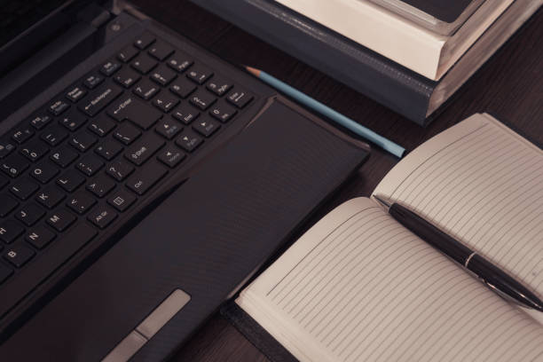 istock An open notepad with clean pages lies next to the laptop. 908004288