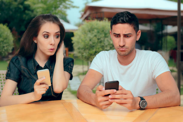 curious girlfriend checking boyfriend phone receiving texts messages - proof of love imagens e fotografias de stock