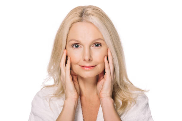istock mature woman touching face 908005074