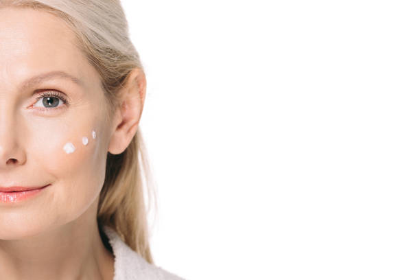 istock mature woman with cosmetic cream on face 908005174
