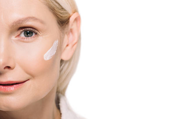 istock mature woman with cosmetic cream on face 908005206
