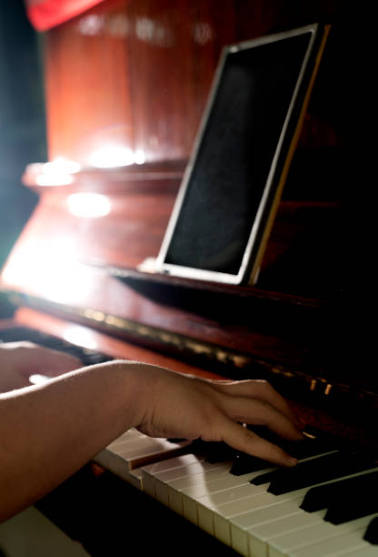 istock Playing Piano in the dark with light up and one tablet 908008358