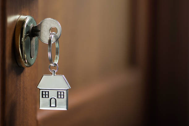 istock Silver house key in a door 908009858