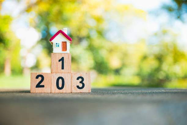 istock Miniature house on wooden podium 908011538