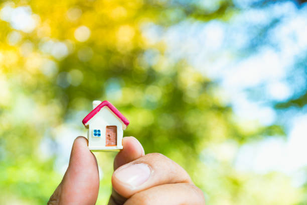 istock Hand holding miniature house 908011558
