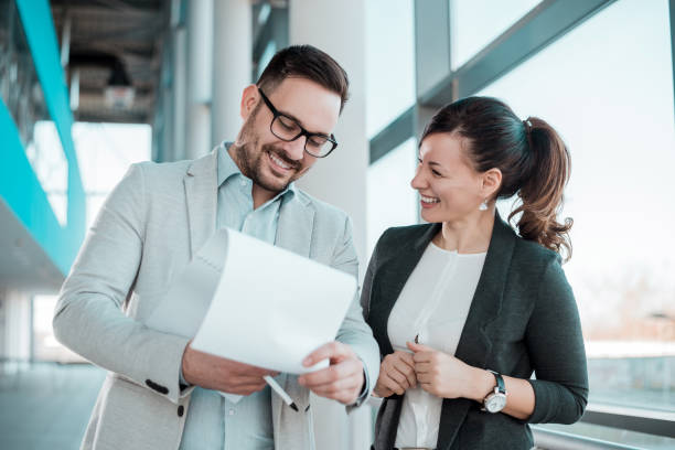 istock Two smiling business people working on new project in office lobby. 908013434