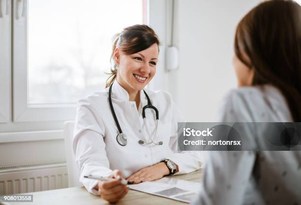 Smiling Young Doctor Having A Medical Exam Stock Photo - Download Image Now - Doctor, Doctor's Office, Patient