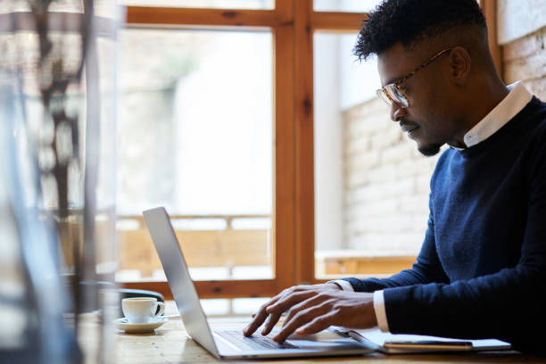 istock Concentrated male graphic designer developing new ideas for improving innovation working on modern laptop with wireless 4G connection. Hipster guy keyboarding on computer and transfer payment online 908015620