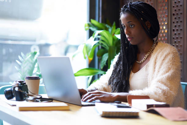 istock Concentrated afro american  freelancer with cornrows typing on keyboard of modern laptop text information in internet websites for searching ideas and creating startup project of business company 908018042