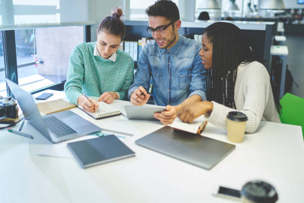 istock Diversity group of talented journalists sharing ideas during informal meeting in coworking office collaborating while creating media project, male and female classmates studying together in library 908019936