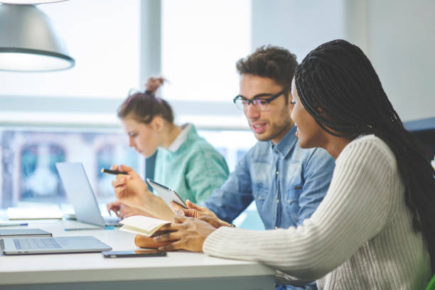istock Group of creative graphic designers working together on creation outlay for web sites discussing ideas and sharing opinions, male and female international students preparing for examination together 908020034
