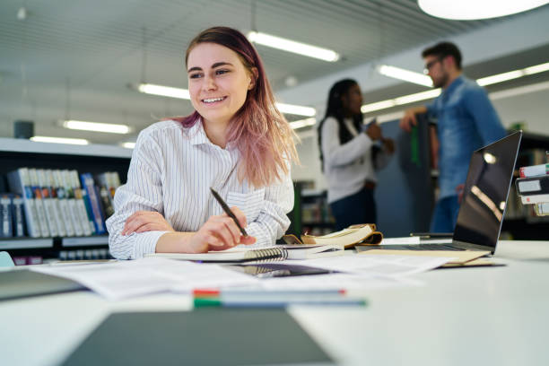 istock Smiling attractive talented journalist writing article for publication feeling happy making creative solution, young female student enjoying free time in university campus while preparing to exams 908020168